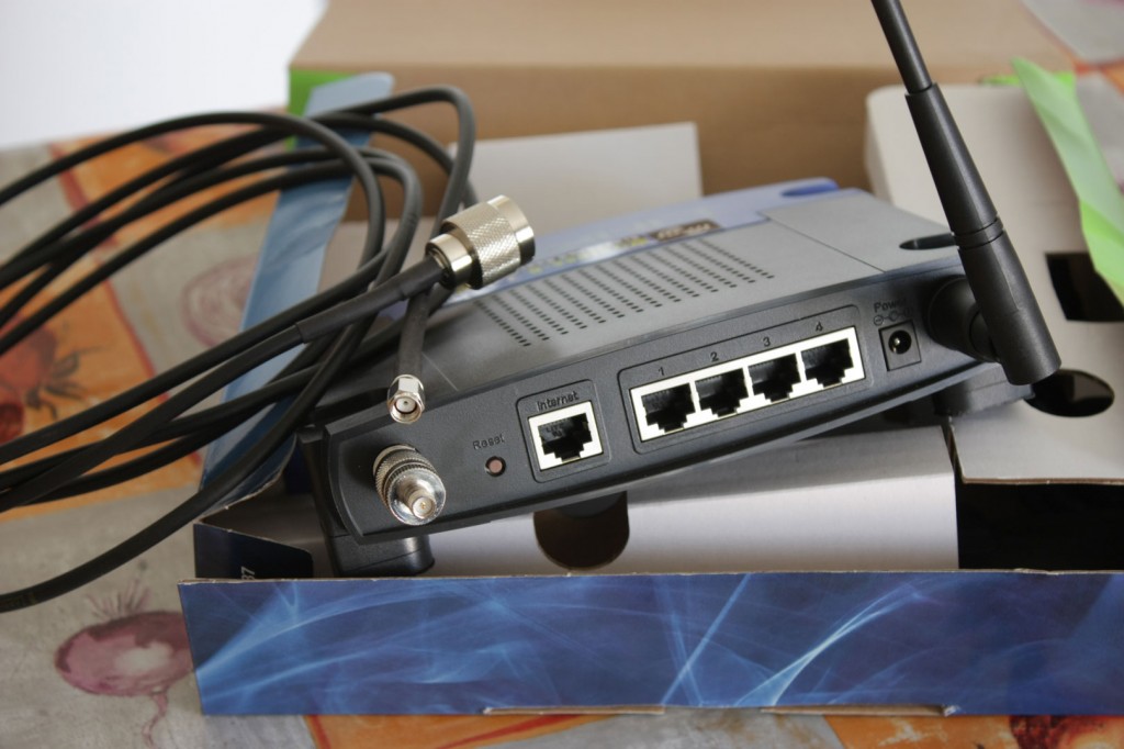 Router Wifi como repetidor, con una antena retirada y el adaptador RP-TNC a RP-SMA puesto para poder usar el cable